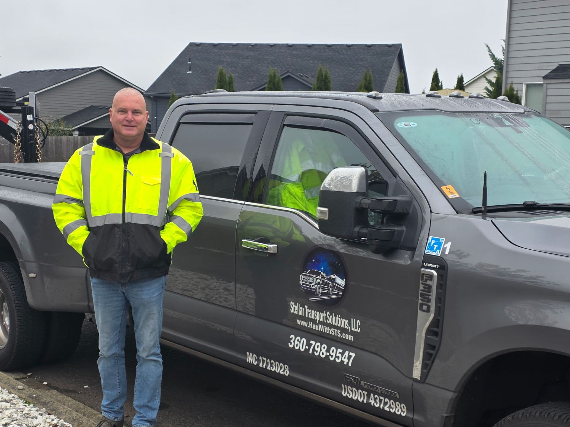 Robert, the owner-operator, standing with the branded Stellar Transport F-350
